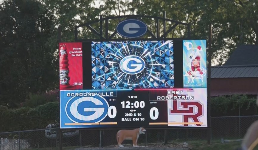 24ft by 14ft LED videoboard at a Gordonsville football game, showing live score and down and distance with sponsor panels either side of the video window